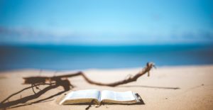 Image of open book on beach. Beautiful horizon. Read, Watch, Listen. Spotlight