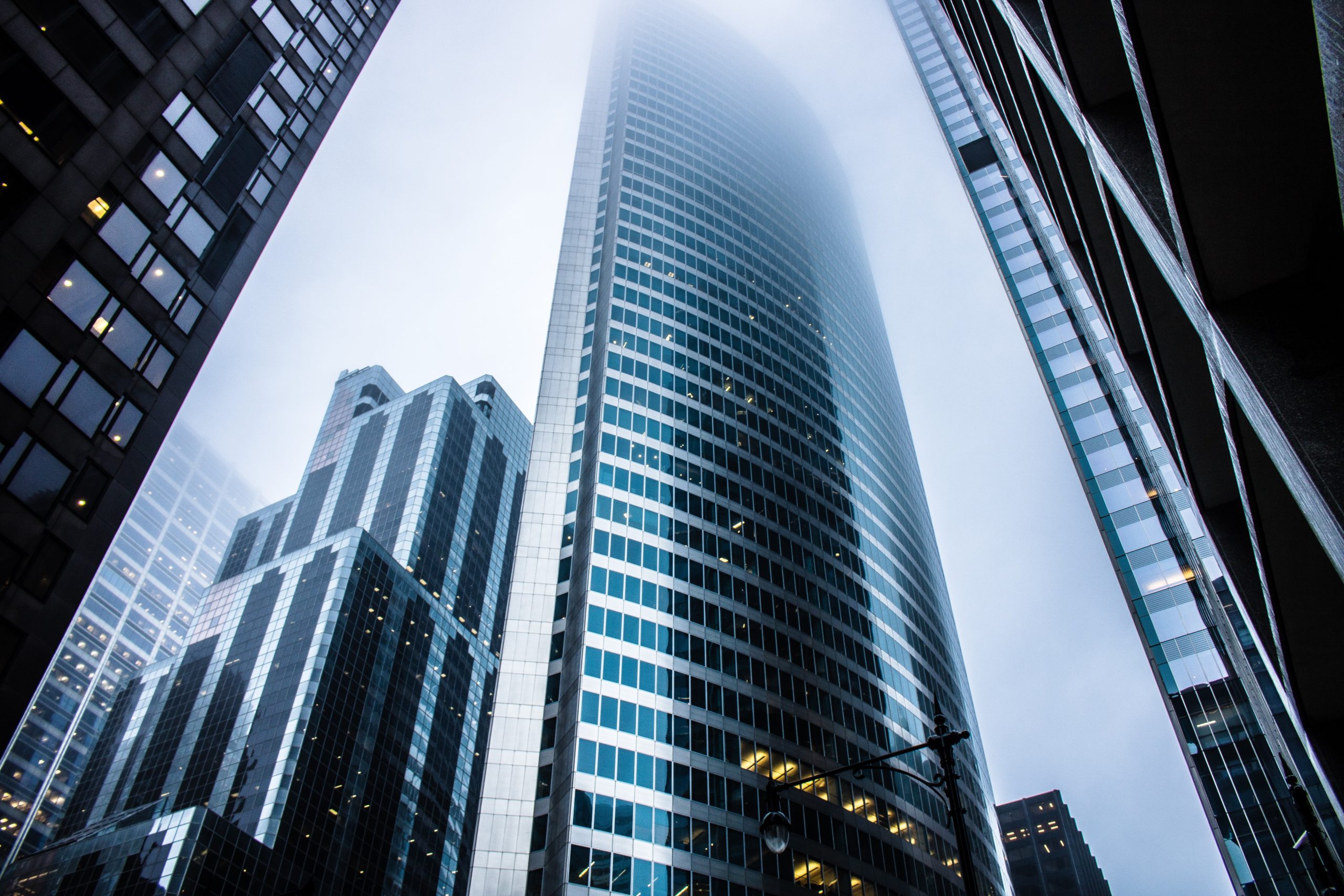 looking up at tall buildings reaching the clouds