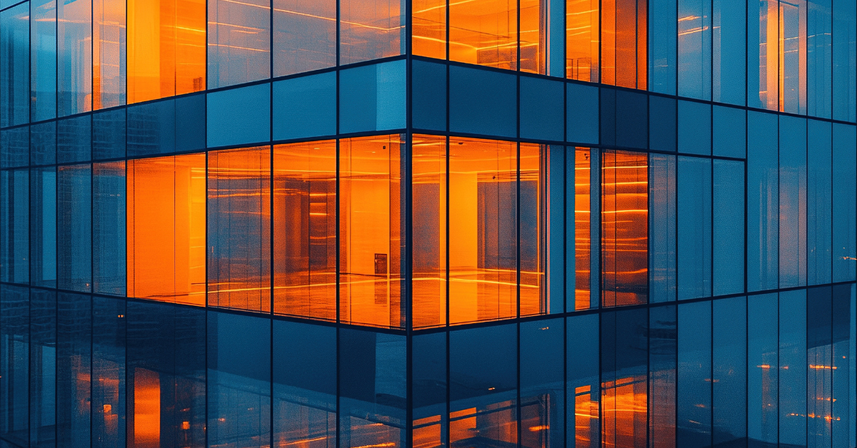 A modern glass building reflecting warm orange light, showcasing contemporary architecture and urban design.