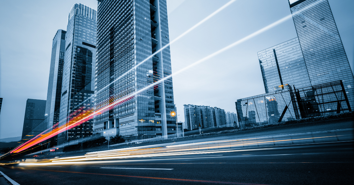 light trails on road in front of tall office buildings