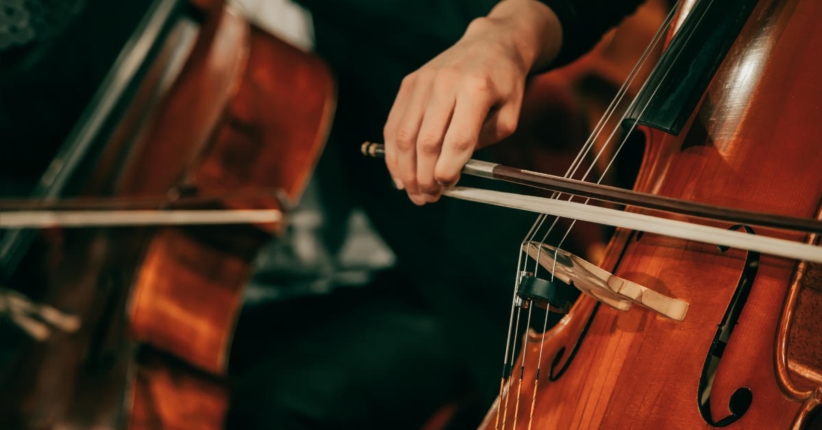 Downloaded File #: 307855295 Symphony orchestra on stage, hands playing cello. Shallow depth of field, vintage style, signifying hiring